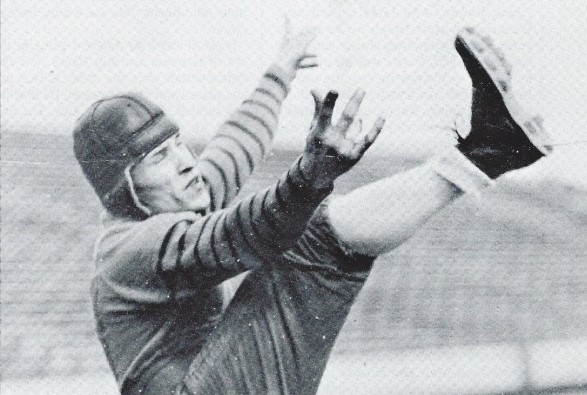 Harold Red Grange holding his football jersey number. His number 77 was  retired at the University