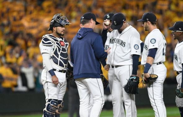 Former Seattle Mariners pitcher Felix Hernandez, front right, talks with  manager Scott Servais, left, after being inducted into the Mariners Hall of  Fame before a baseball game between the Mariners and the